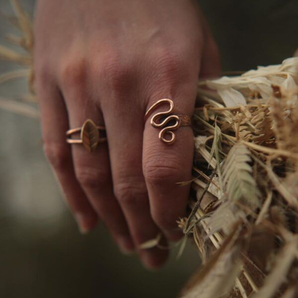 Two handmade rings on hand holding dried florals.