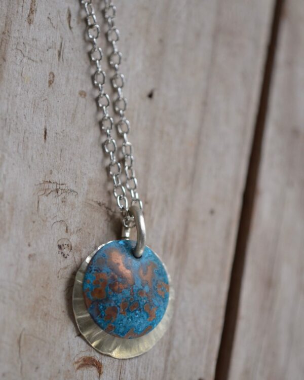 blue patina overlay on textured brushed nickel dome necklace close up vertical
